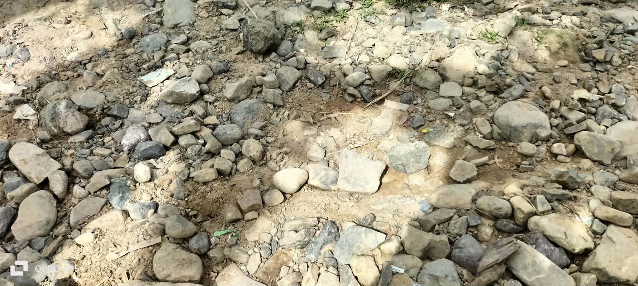 Loose stones and exposed earth on a rough community access route