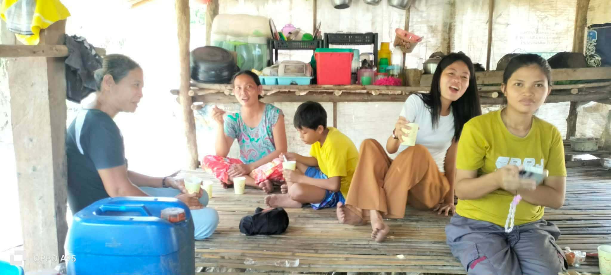 Community members spending time together inside a simple open shelter